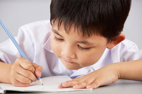 بچه درحال نوشتن و استفاده از پاک‌کن